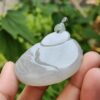 Una mano sosteniendo un colgante de jade.