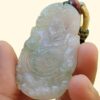 a hand holding a jade pendant