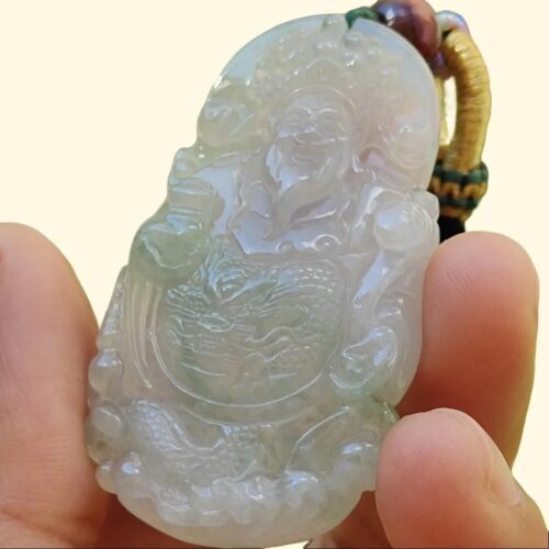 a hand holding a jade pendant