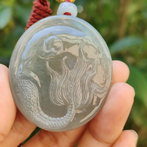 Una mano sosteniendo un colgante de jade.