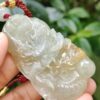 a hand holding a jade pendant