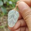 une main tenant un pendentif en or