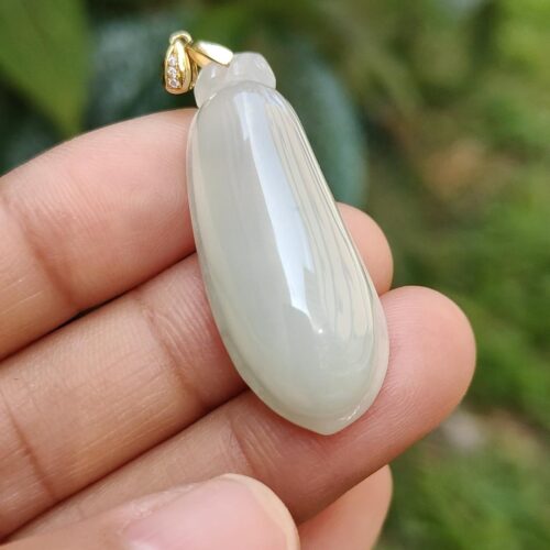 Una mano sosteniendo un colgante de jade.