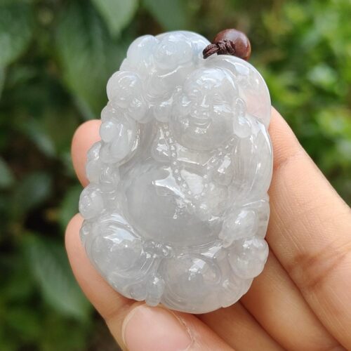 a hand holding a jade pendant