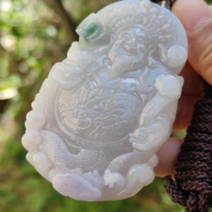 Una mano sosteniendo un colgante de jade.