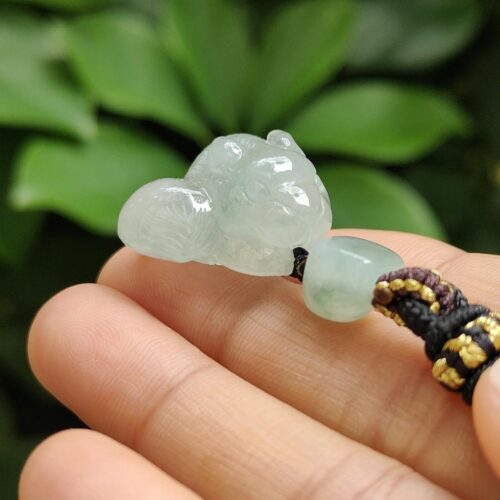a hand holding a jade bead