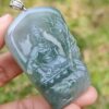 a hand holding a jade pendant