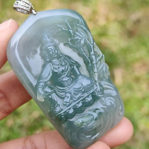 a hand holding a jade pendant