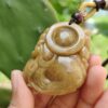Una mano sosteniendo un colgante de jade.