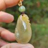 Una mano sosteniendo un colgante de jade.
