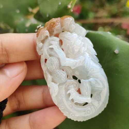 tangan memegang liontin giok