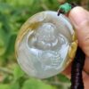 a hand holding a jade pendant