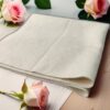 a white towel with pink roses on a table