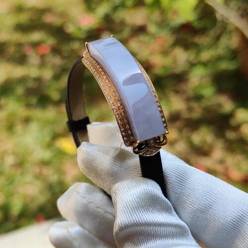 a hand in glove holding a bracelet