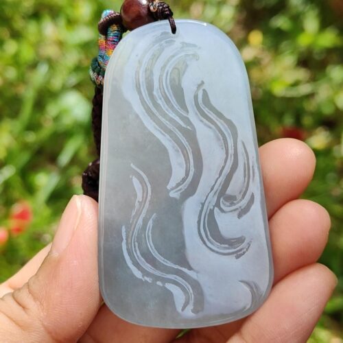 Una mano sosteniendo un colgante de jade.