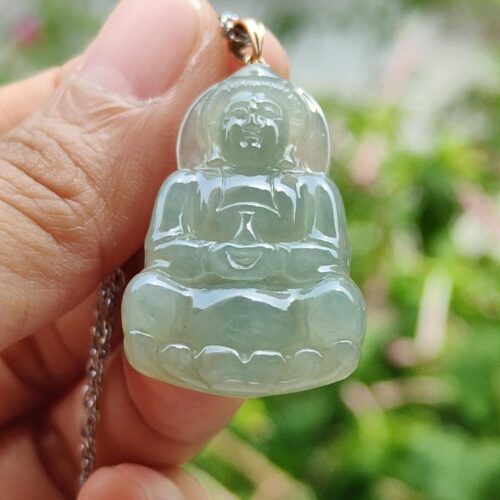 a hand holding a jade pendant