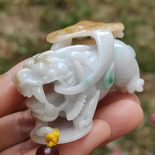 a hand holding a small white stone animal