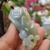 a hand holding a jade pendant