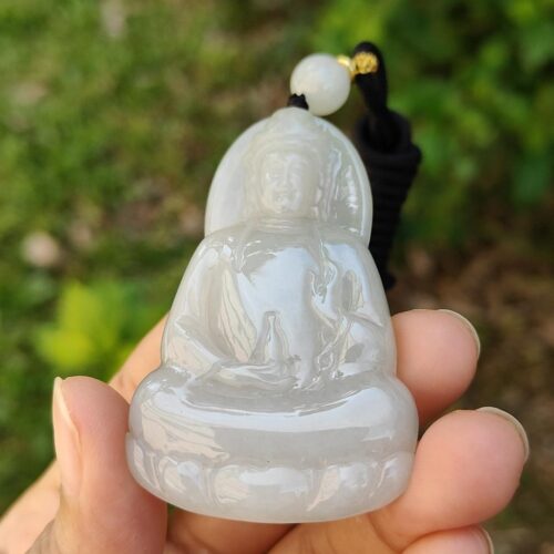 Una mano sosteniendo un colgante de jade.