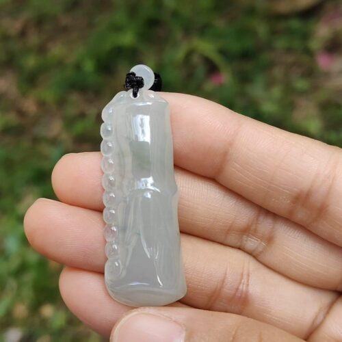 Una mano sosteniendo un colgante de jade.
