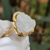 a ring with a carved white stone in a gold ring