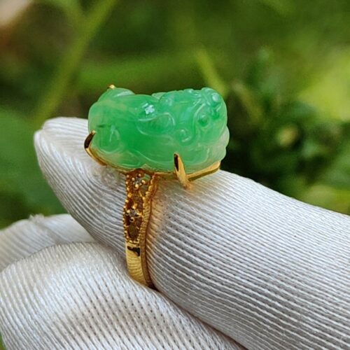 a hand wearing a gloved finger with a jade ring