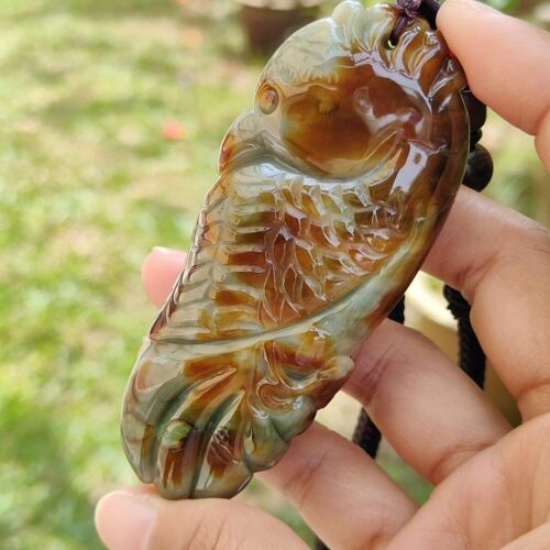 a hand holding a stone pendant