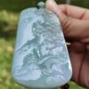 a hand holding a jade pendant