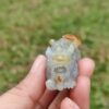 Una mano sosteniendo un pequeño animal de piedra.