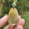 Una mano sosteniendo un colgante de jade.