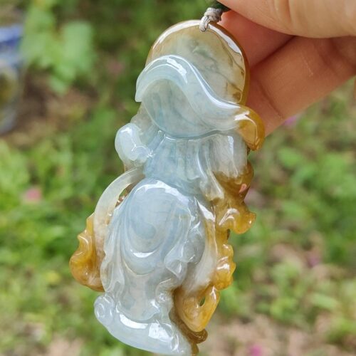 Una mano sosteniendo un colgante de jade.