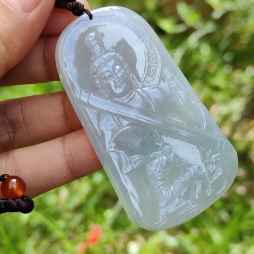 Una mano sosteniendo un colgante de jade.