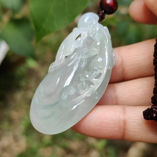 Una mano sosteniendo un colgante de jade.