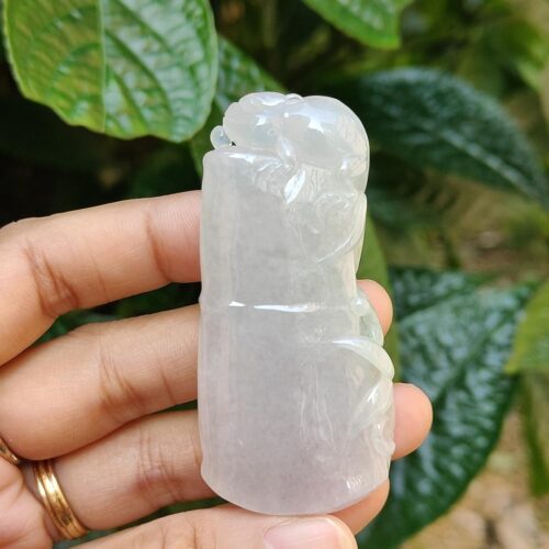Una mano sosteniendo un objeto de jade blanco.