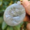 Una mano sosteniendo un colgante de jade.