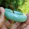 a hand holding a jade bracelet