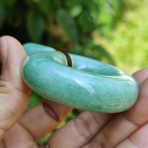 a hand holding a jade bracelet