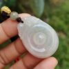 Una mano sosteniendo un colgante de jade.