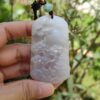 Una mano sosteniendo un colgante de jade.