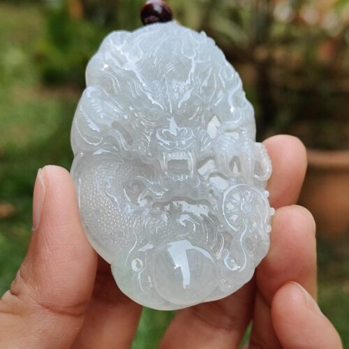 Una mano sosteniendo un colgante de jade.
