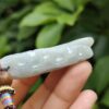 a hand holding a jade bead