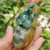 a hand holding a jade sculpture