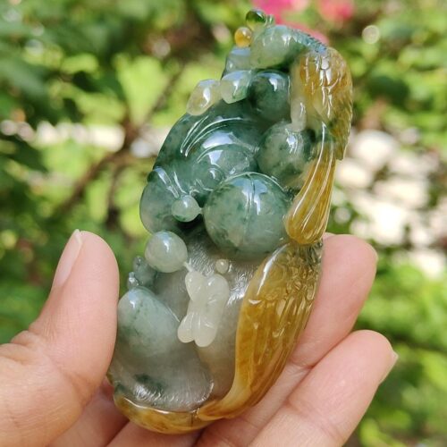 a hand holding a jade sculpture