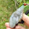 Una mano sosteniendo un colgante de jade.