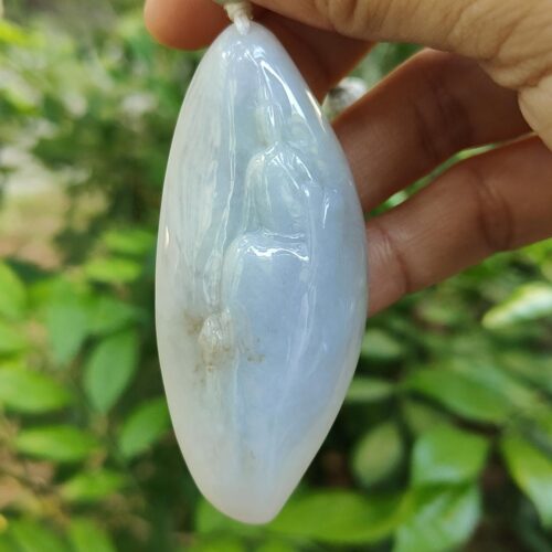 a hand holding a white oval object