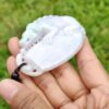 Una mano sosteniendo un colgante de jade.