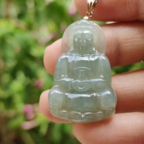 a hand holding a jade pendant