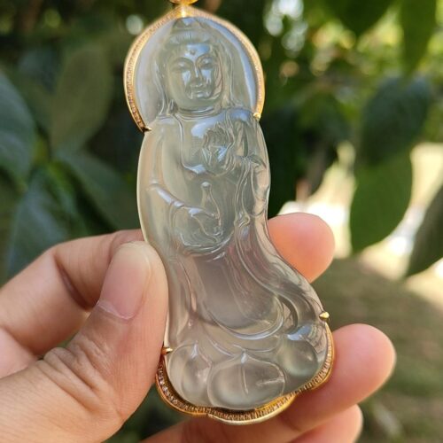 Una mano sosteniendo un colgante de jade.