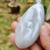 a hand holding a white stone