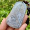 Una mano sosteniendo un colgante de jade.